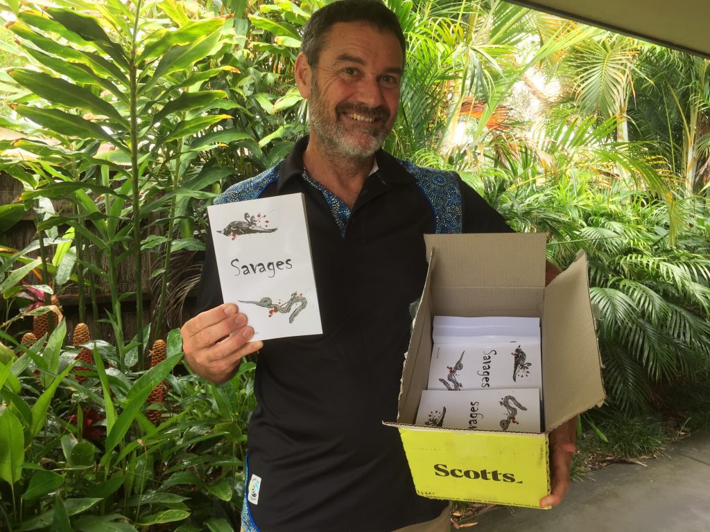 Steve Trotter holding a copy of 'Savages.'